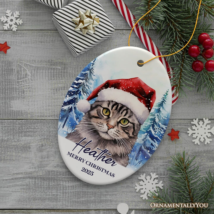 Tabby Cat with Santa Hat Personalized Ornament, Winter Forest Christmas Gift With Custom Name and Date Ceramic Ornament OrnamentallyYou Oval