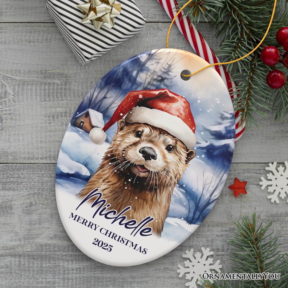 Otter with Santa Hat Personalized Ornament, Festive Christmas Gift With Custom Name and Date Ceramic Ornament OrnamentallyYou Oval