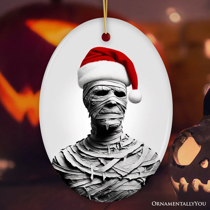 Ghoulish Mummy with Santa Hat Ornament, Sinister Holiday Keepsake for Halloween Lovers Ceramic Ornament OrnamentallyYou Oval
