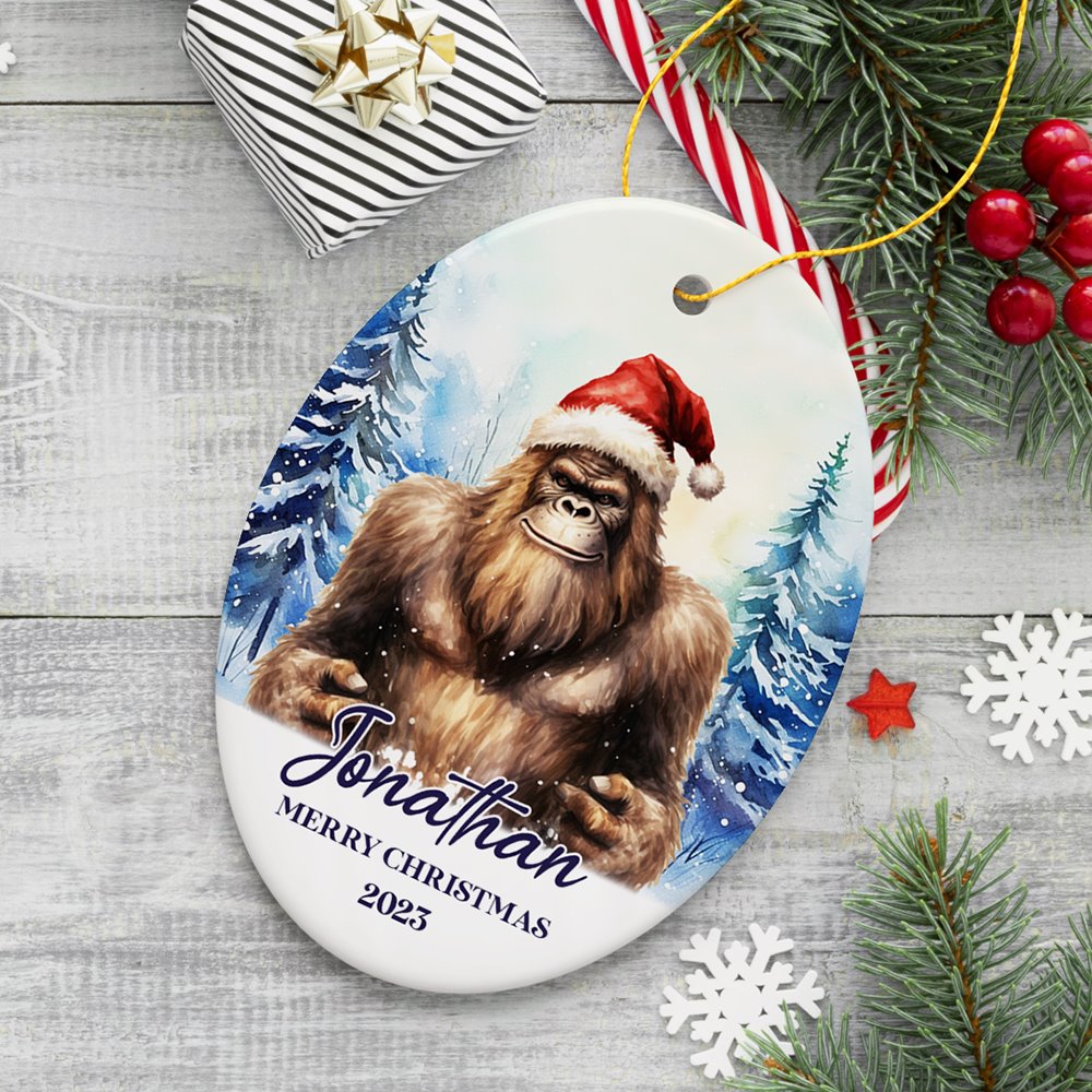Bigfoot with Santa Hat Personalized Ornament, Winter Forest Christmas Gift With Custom Name and Date Ceramic Ornament OrnamentallyYou Oval 