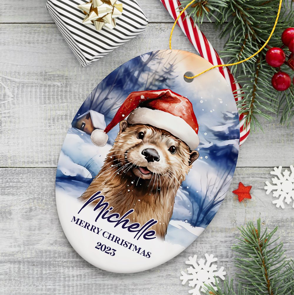 Otter with Santa Hat Personalized Ornament, Festive Christmas Gift With Custom Name and Date Ceramic Ornament OrnamentallyYou Oval 