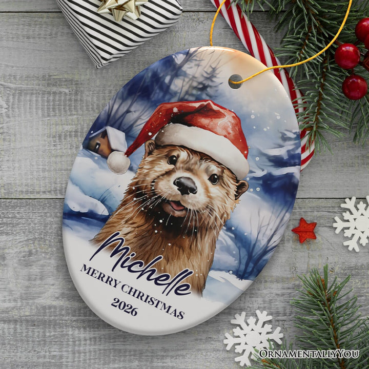 Otter with Santa Hat Personalized Ornament, Festive Christmas Gift With Custom Name and Date Ceramic Ornament OrnamentallyYou Oval 